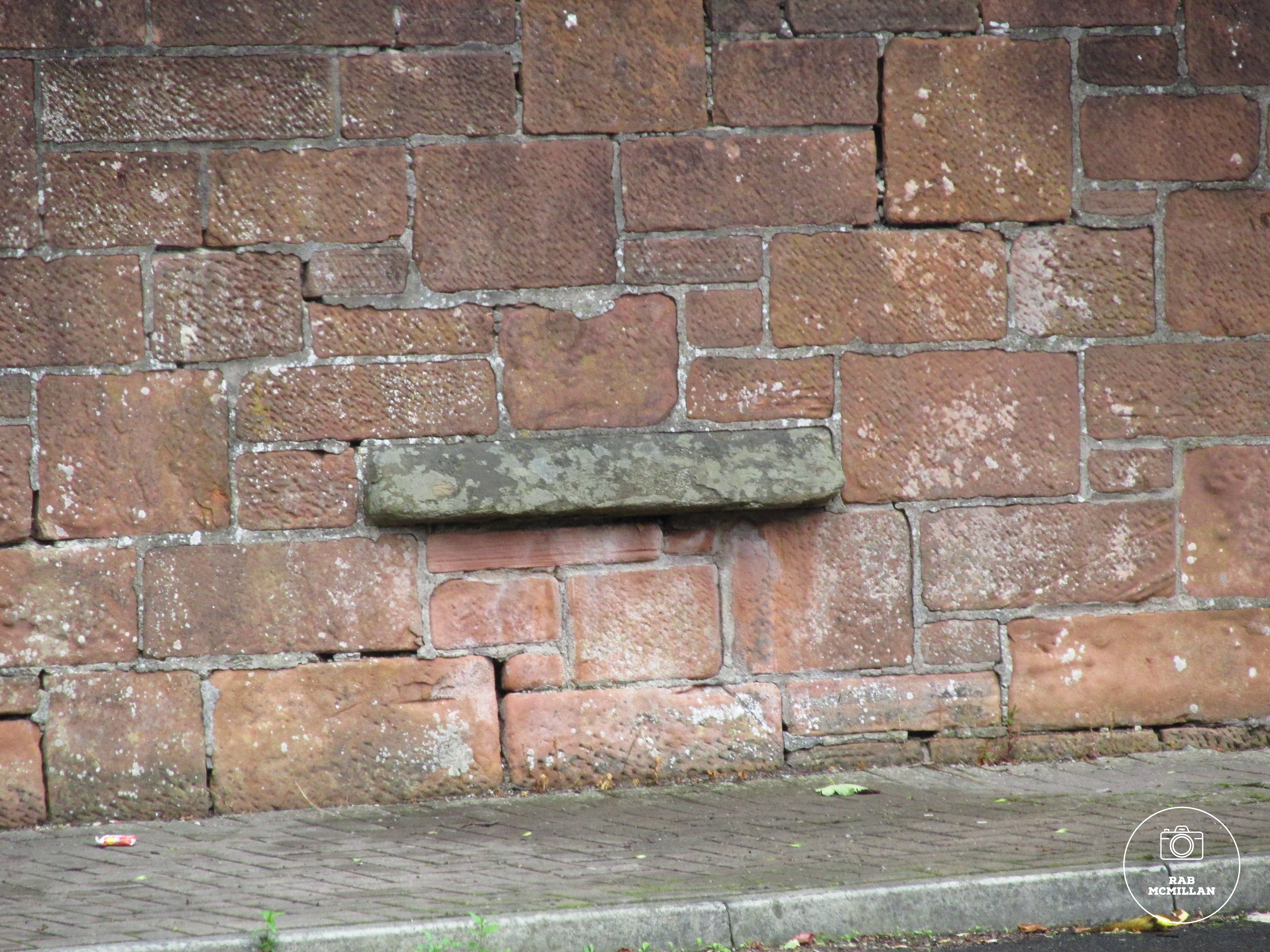 Victorian Slate Pencil sharprning stone in the playground wall of the old Wishaw Public School, 2017.